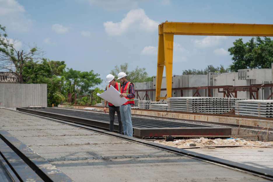 two construction workers looking at plans on a job site